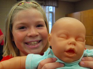 Brianna Kompelien holds up her Red Cross baby. Photo credit: Lynette Nyman/American Red Cross