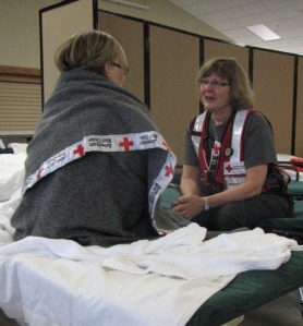 Red Cross disaster relief worker Lori Dehn talks with a shelter resident, Sebeka High School, May 16, 2013.