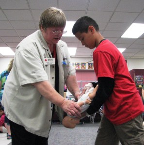 Red Cross instructor Debbie Foster helps a student during a babysitter's training class at Red Lake Elementary school in Red Lake, MN, on June 20, 2013.