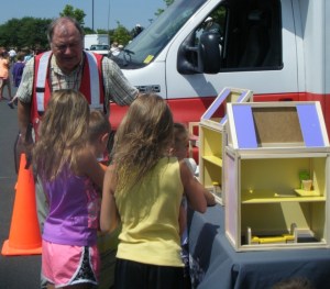 A Red Cross volunteer sparks the conversation about fire safety using a new dollhouse, Maple Grove, Minnesota, 2013.