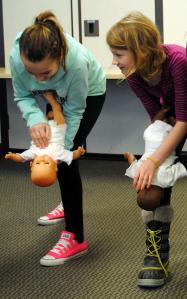During a Babysitter's Training course in Minneapolis, Minn., youth learn that CPR is performed differently on infants than on children and adults. Techniques are performed here that require hands-on skills focusing on back blows, chest thrusts and proper ways to safely hold an infant. Photo credit: Krista Weiler/American Red Cross